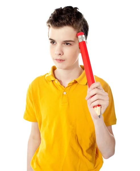 Tankeväckande pojke hålla en penna — Stockfoto