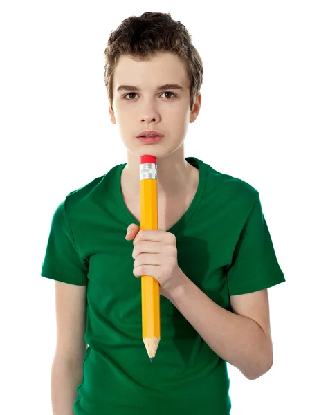 Escola menino pensando enquanto segurando lápis — Fotografia de Stock