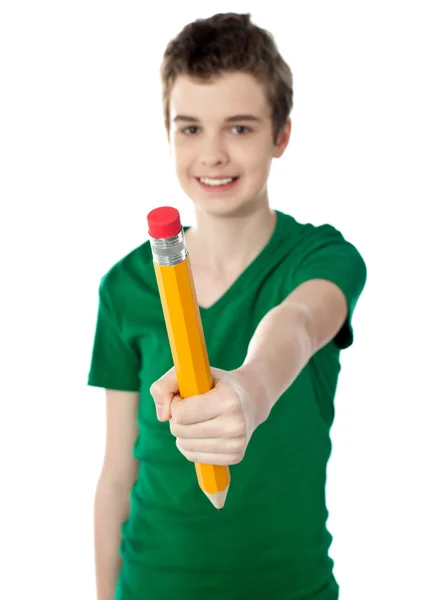 Ung pojke visar stor gul penna — Stockfoto