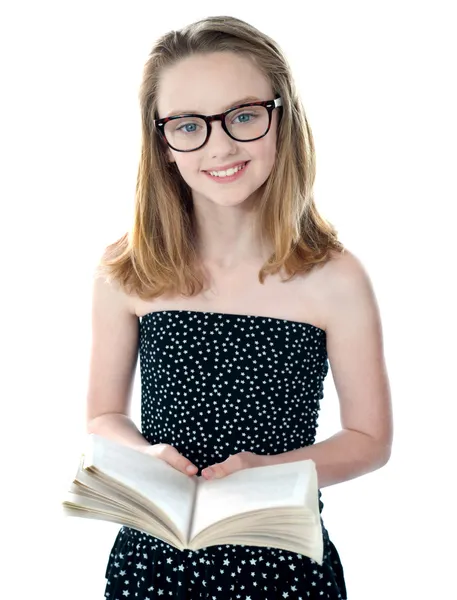 Милая маленькая девочка, стоящая с открытой книгой — стоковое фото
