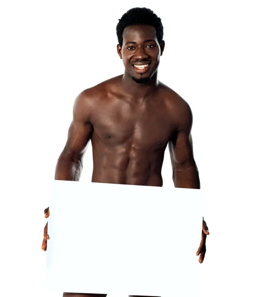 Young muscular man holding blank billboard — Stock Photo, Image