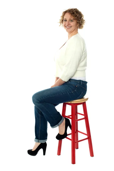 Pewnie starszy kobieta spoczywa na stołek — Zdjęcie stockowe