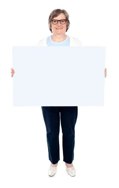 Boş beyaz tahta holding gülümseyen yaşlı kadın — Stok fotoğraf