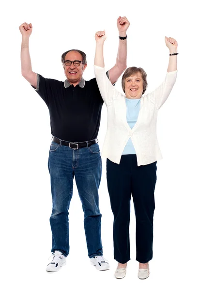 Excited aged couple posing with raised arms — Stock Photo, Image