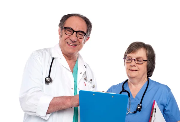 Médicos seniores lendo relatório médico — Fotografia de Stock