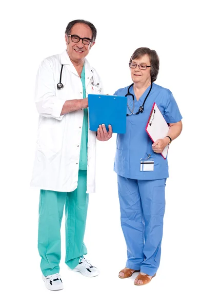 Médico e enfermeiro analisando relatório juntos — Fotografia de Stock
