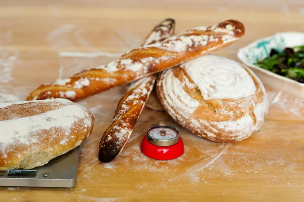 Baguetes e pães na mesa de madeira — Fotografia de Stock