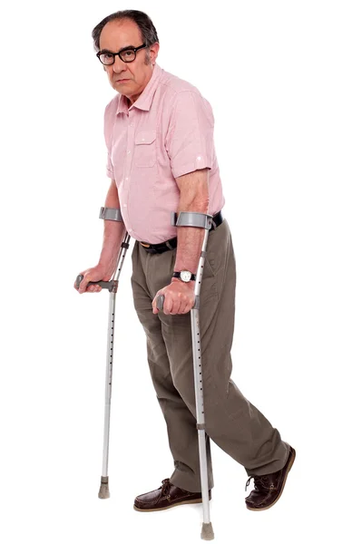 Depressed senior male with two crutches — Stock Photo, Image