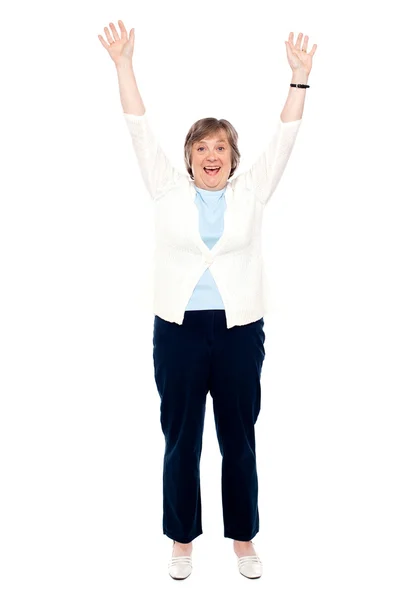 Aufgeregte Seniorin posiert mit erhobenen Armen — Stockfoto