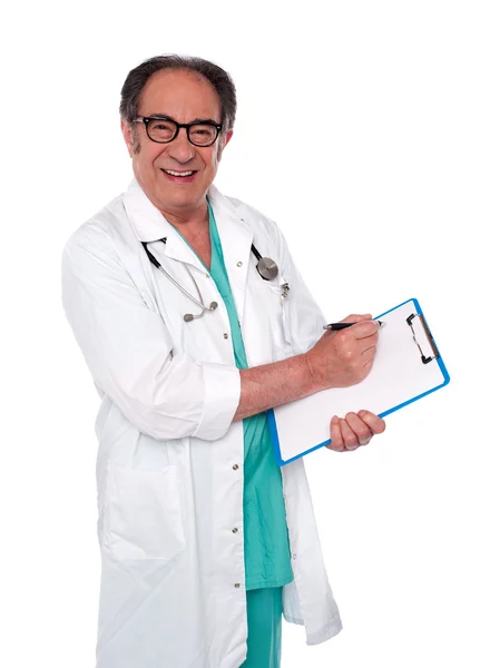 Cirurgião sênior escrevendo relatório médico — Fotografia de Stock