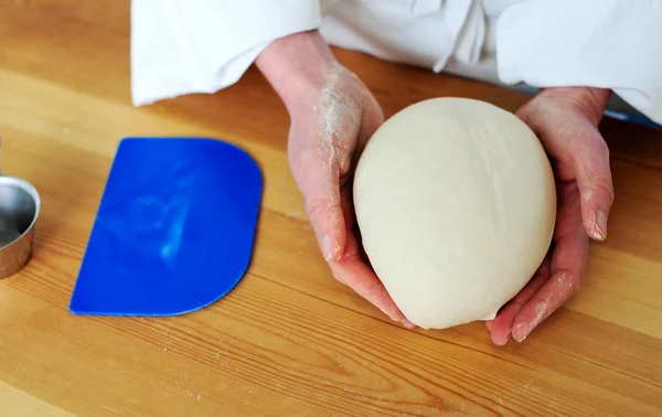 Chefs hand holding a clean finished dough — Stock Photo, Image