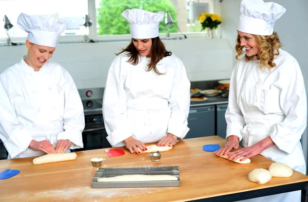 Beautiful female chefs kneading dough — Stock Photo, Image
