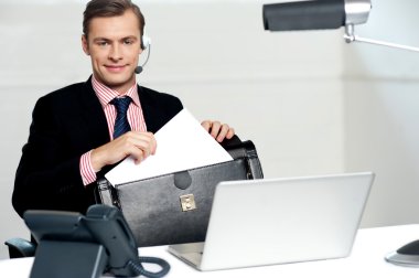 Male call centre executive arranging paper works clipart