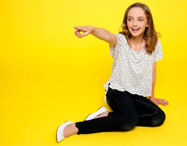 Smiling young girl pointing away — Stock Photo, Image