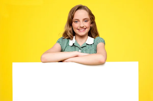 Mädchen posiert hinter einer Werbetafel — Stockfoto