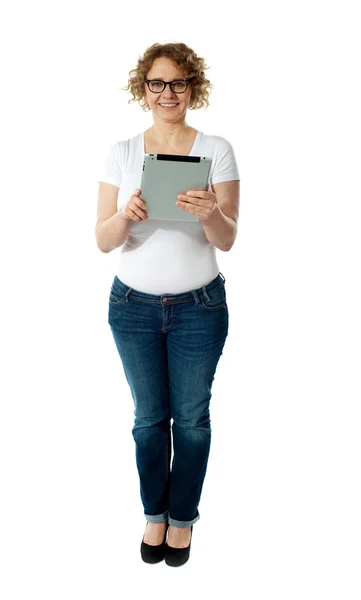 Полная длина симпатичной женщины, держащей планшетный компьютер — стоковое фото
