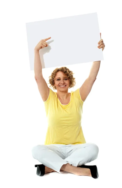 Senior woman pointing at blank ad board — Stock Photo, Image