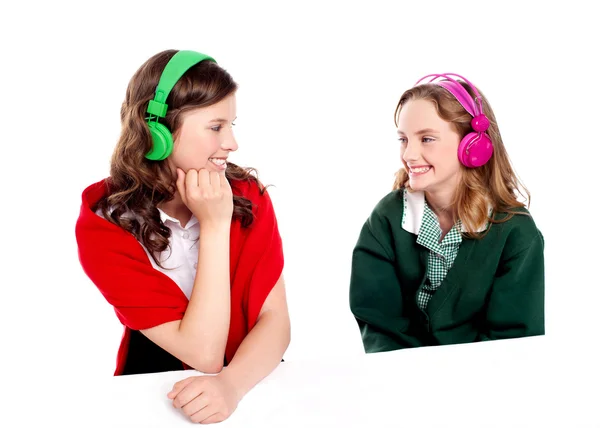 Pretty girls enjoying music. Looking at each other — Stock Photo, Image