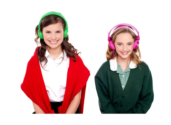 Schoolgirls listening music through headphones — Stock Photo, Image