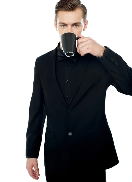 Intelligente giovane che beve caffè in tazza nera — Foto Stock