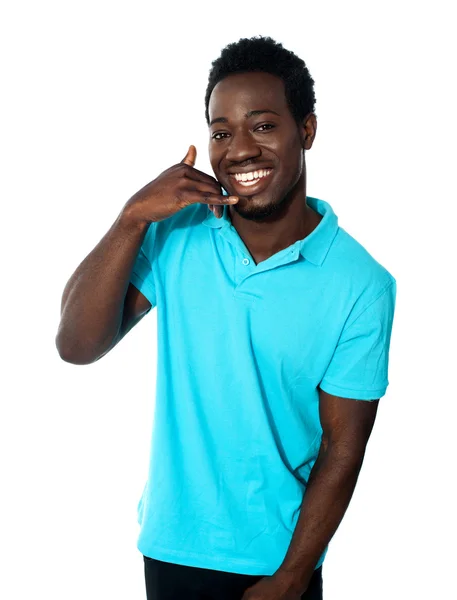 Uśmiechający się młody człowiek pokazano wywołanie gest — Zdjęcie stockowe