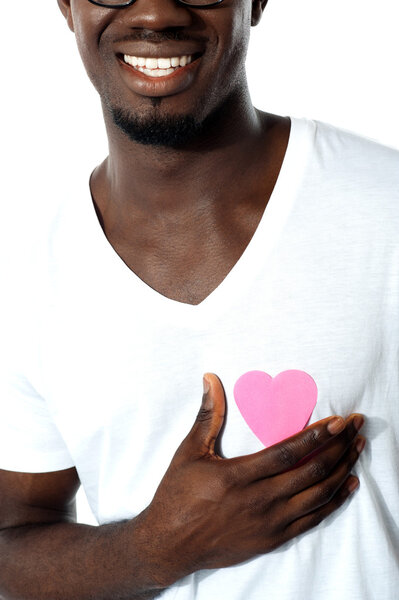 Cropped image of an African boy holding paper heart on his chest