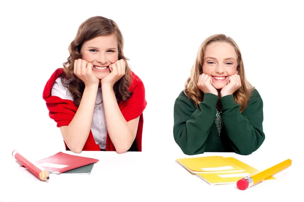 Jovens raparigas felizes sentadas à secretária — Fotografia de Stock