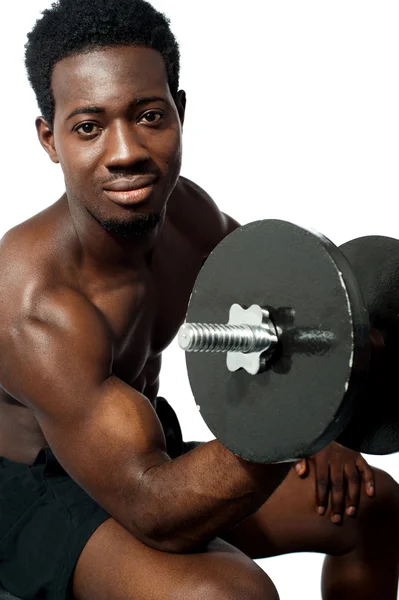 Mächtiger junger Mann beim Heben von Gewichten — Stockfoto