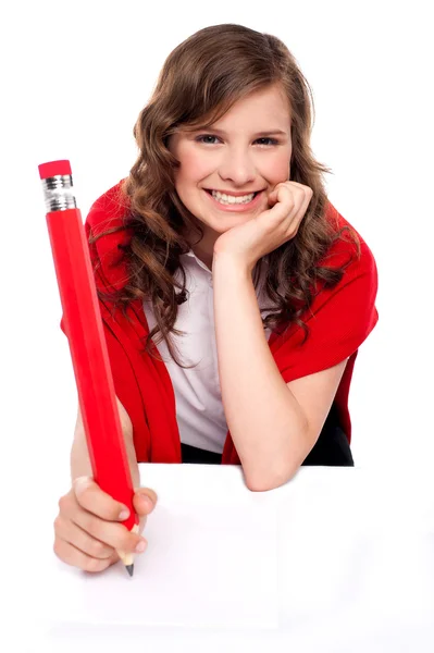 Щасливий підліток пише з великим червоним олівцем — стокове фото
