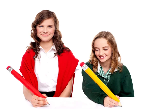 Chicas alegres escribiendo con lápiz en la superficie —  Fotos de Stock