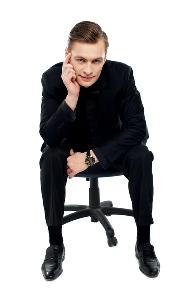 Przystojny młody kaukaski mężczyzna siedzi na krześle — Zdjęcie stockowe