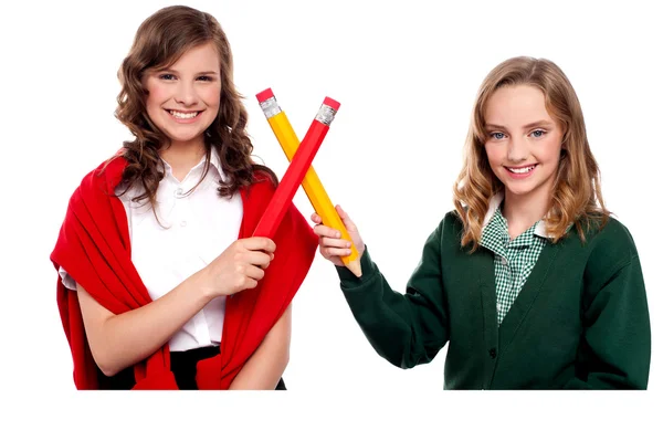 Smiling teenagers making cross sign with pencil — Stock Photo, Image