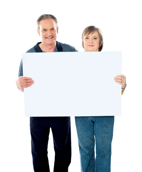 Husband and wife displaying advertising board — Stock Photo, Image