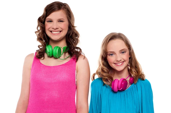 Adolescentes posando com fones de ouvido ao redor do pescoço — Fotografia de Stock