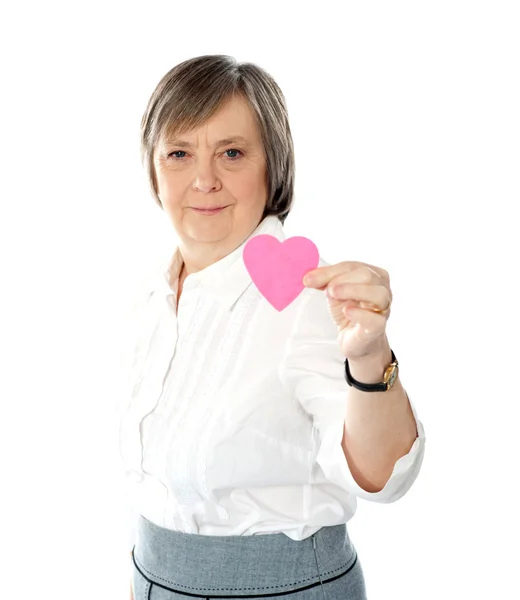 Γυναίκα που δείχνει την καρδιά σχήμα ροζ χάρτινο — Φωτογραφία Αρχείου