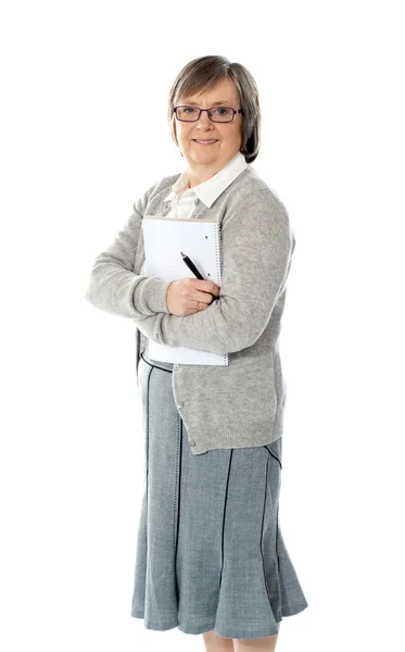 Mujer mayor sosteniendo bloc de notas en espiral y pluma — Foto de Stock