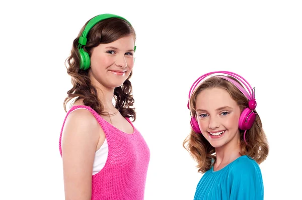 Elder and younger sisters listening to music — Stock Photo, Image