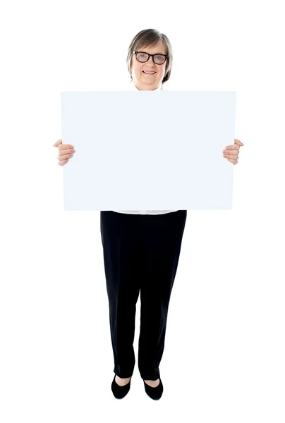 Executiva sênior mostrando placa de publicidade — Fotografia de Stock