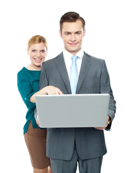 Woman pointing into laptop while guy holding it — Stock Photo, Image