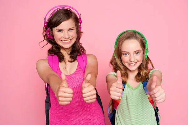 Two beautiful schoolgirls giving thumbs up — Stock Photo, Image