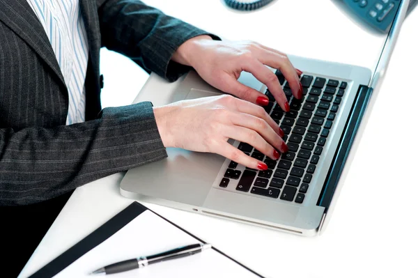 Жіночі руки друкуються на клавіатурі ноутбука. Обрізане зображення — стокове фото