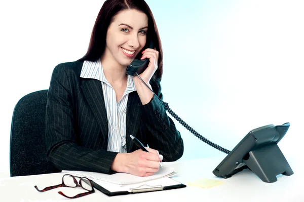 Företagare som tar emot samtal på telefon och skrivande — Stockfoto