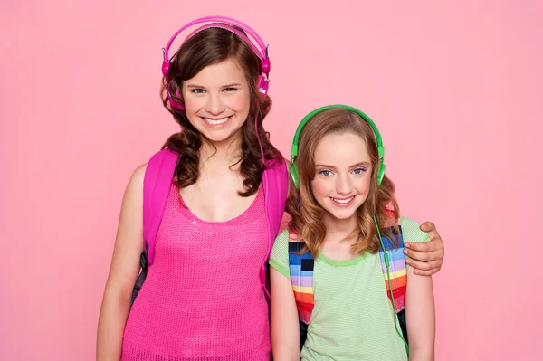 Sisters standing together and enjoying music — Stock Photo, Image