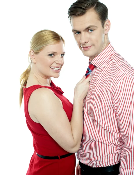 Girl in red holding businessman by his tie — Stock Photo, Image