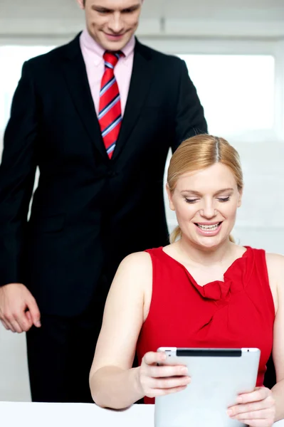 Chefe operando tablet pc e assistente olhando — Fotografia de Stock