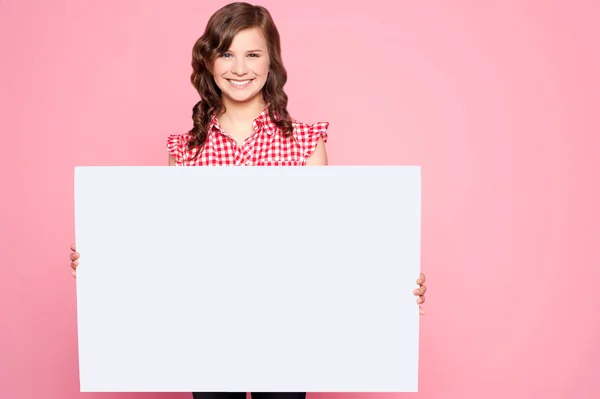 Beautiful girl holding blank billboard — Stock Photo, Image