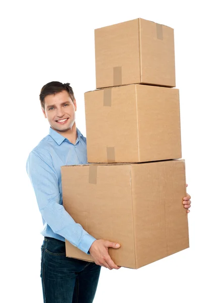 Happy young man carrying heavy packages — Stock Photo, Image