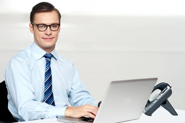 Bonito corporativo masculino amarração no laptop — Fotografia de Stock