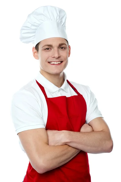Sonriente joven chef posando con los brazos cruzados — Foto de Stock