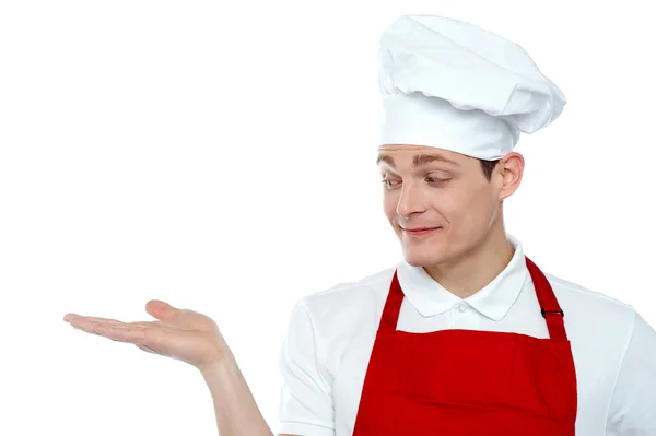 Chef looking at his hand. Offering cooked food — Stock Photo, Image